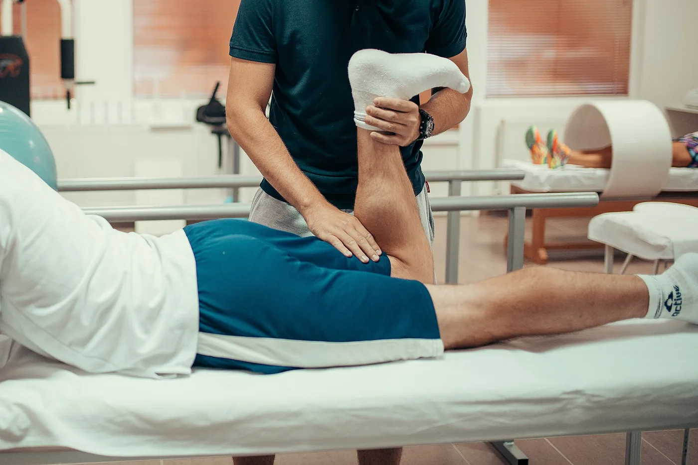 A physiotherapist examining a patient's leg during an assessment